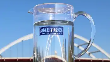 pitcher of water with Metro Water Services logo in front of bridge
