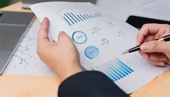 photo: image shows a persons hands holing a document with various graphs and charts.