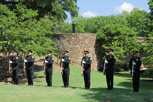 Metro Police Rifle Team standing at attention while bugler plays in the background