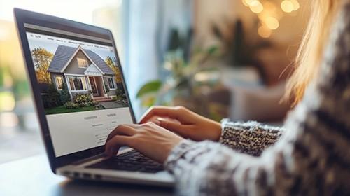 Photo of person using laptop to look at house listing