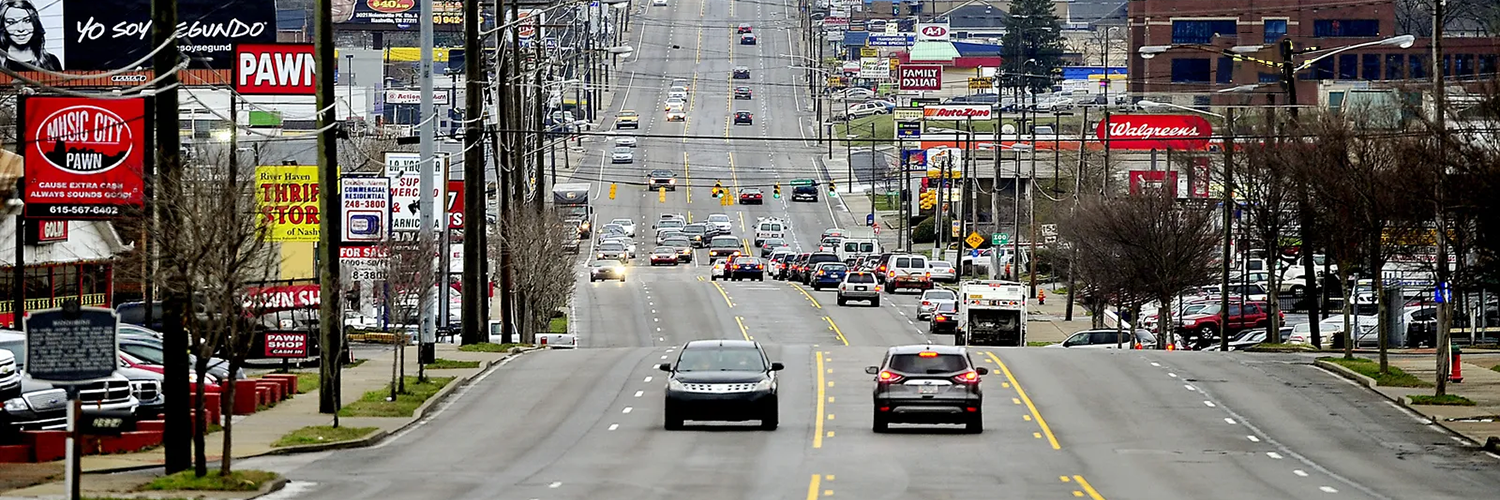 Photo of Nolensville Road in Nashville showing businesses and traffic.
