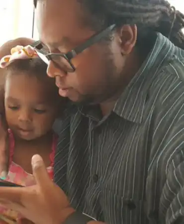 man and girl looking at cell phone