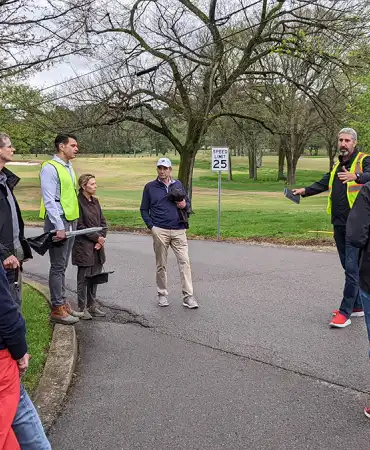 group of people talking on a path in a park