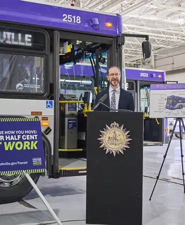 Photo of Mayor O'Connell speaking in front of bus